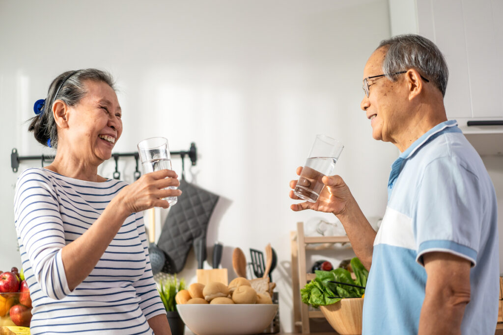 asian senior elderly couple drink glass water kitchen home mature older thirsty grandparent holding clean mineral natural cup after waking up sip morning health care house