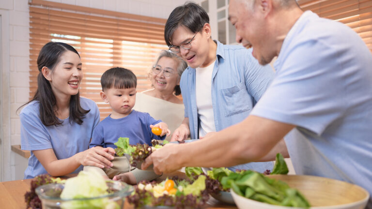 happy asian family preparing food together bright kitchen