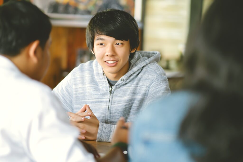 group diverse teenagers sitting table classroom talking university lecture room with students chatting break